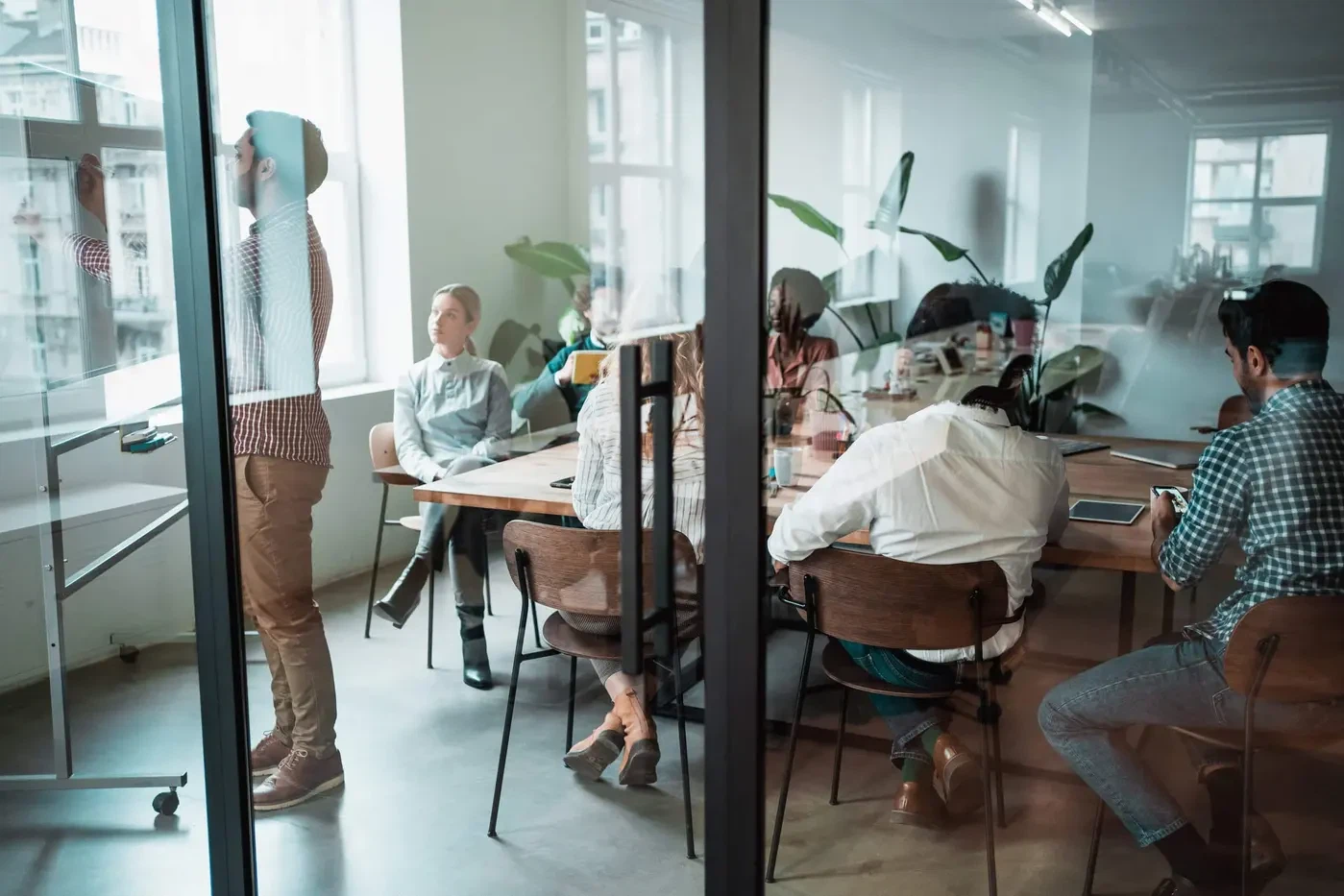 Employer Branding Strategie für Unternehmen: Ein diverses Team arbeitet in einem modernen Meetingraum gemeinsam an einer starken Arbeitgebermarke.