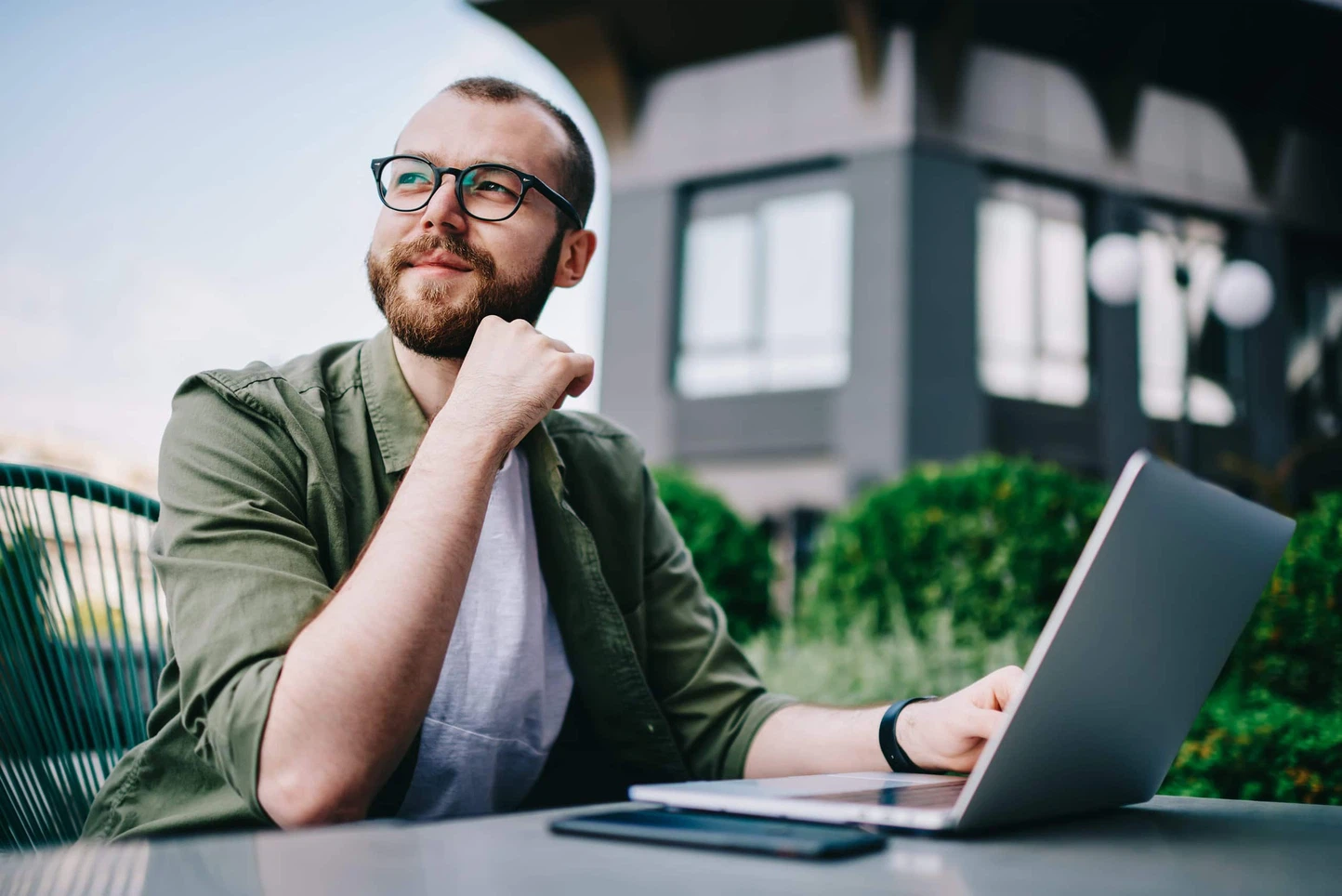 Vergleich moderner Website-CMS: Ein Webentwickler sitzt nachdenklich am Laptop und wählt das passende Content-Management-System aus.