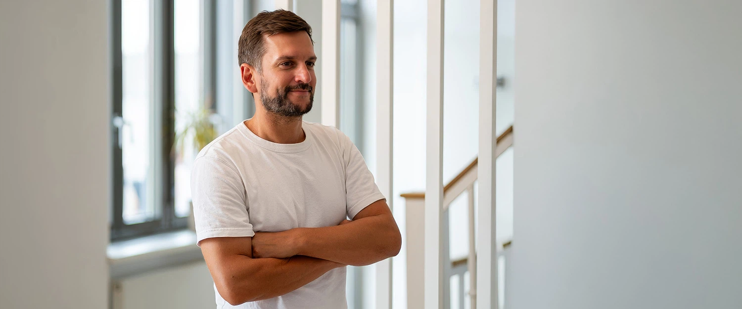 Employer Branding bei der MMCAGENTUR: Ein Mitarbeiter steht in einem hellen Büro vor großen Fenstern.