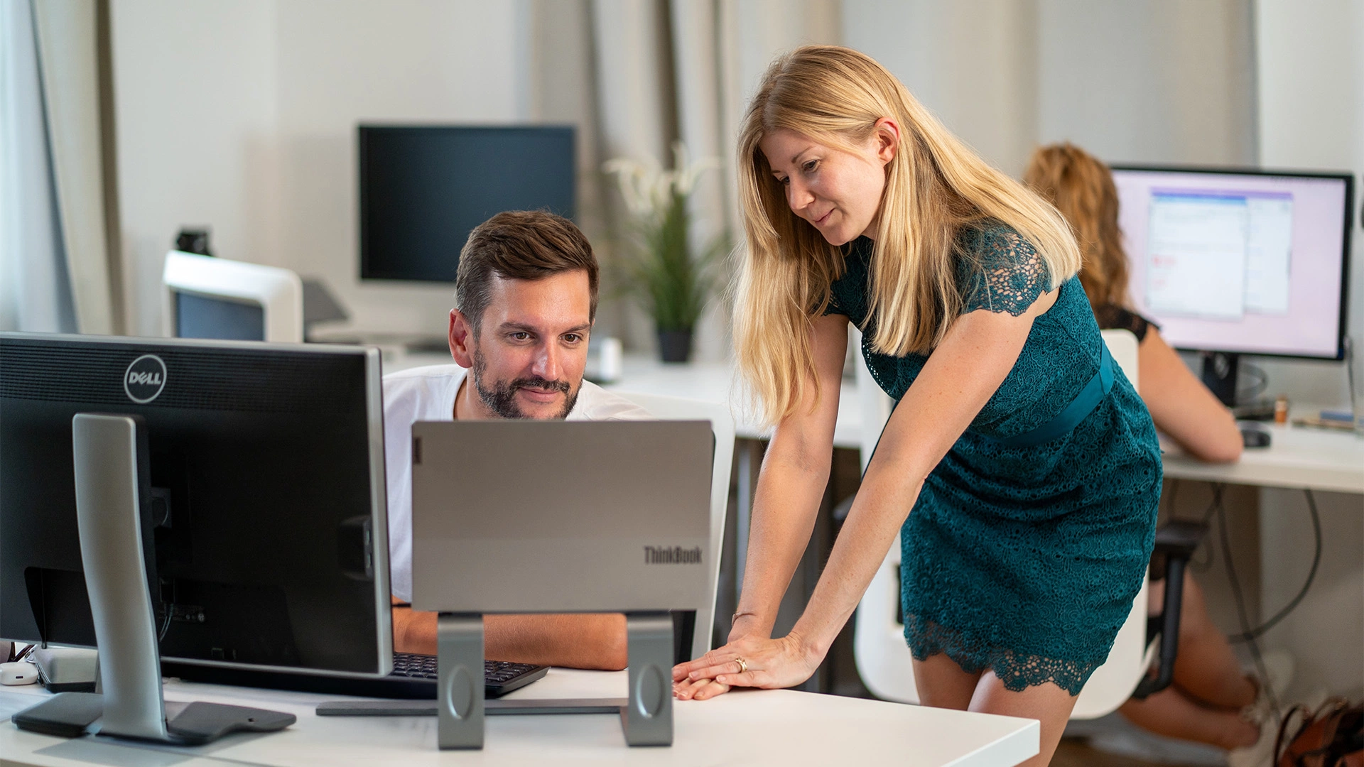 Marketing-Workshop bei MMCAGENTUR: Zwei Kolleg:innen arbeiten gemeinsam an einem Arbeitsplatz im hellen Agenturbüro.