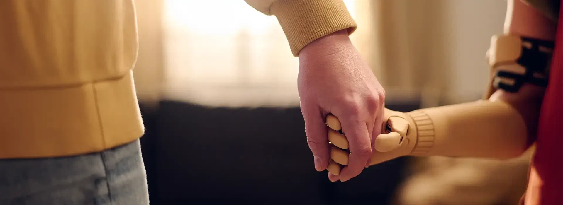 Gesetzliche Barrierefreiheit für Websites: Eine menschliche Hand hält die bionische Handprothese einer anderen Person als Symbol für digitale Inklusion.